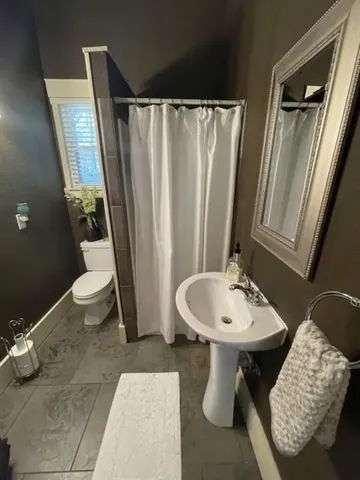 a bathroom with a sink toilet and a mirror