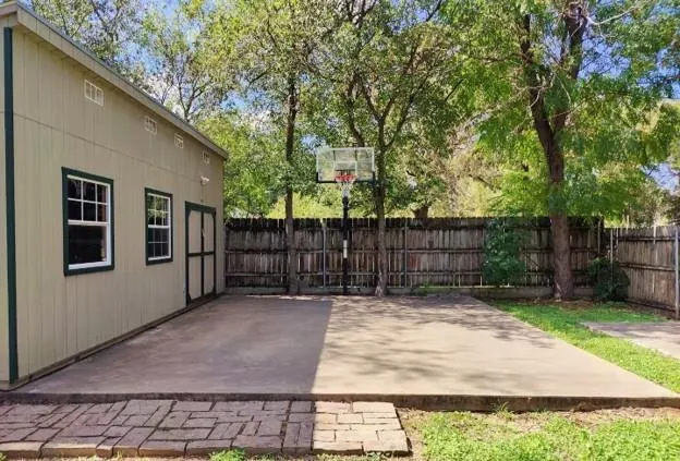 a view of backyard with tree and wooden fence