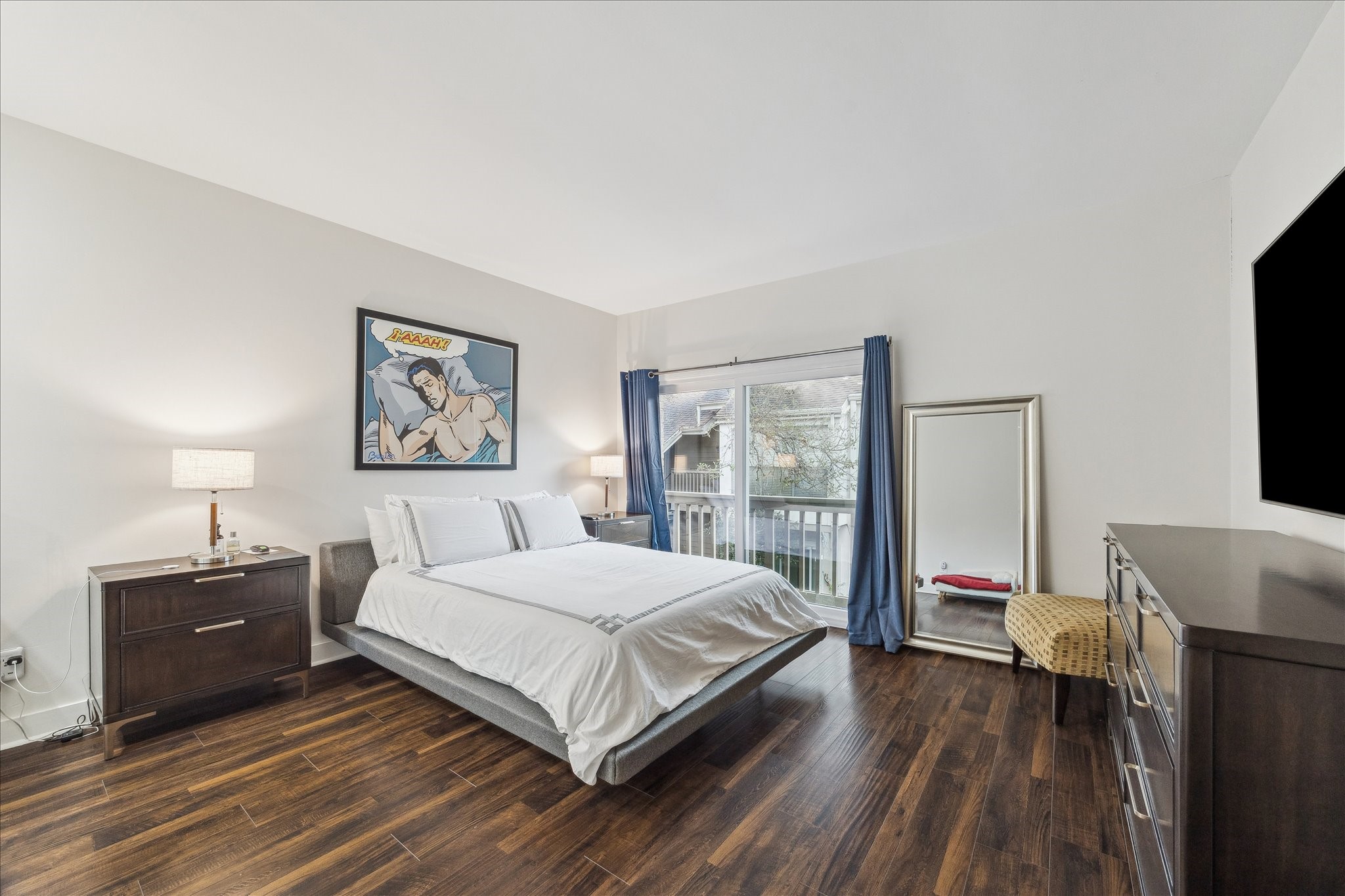 2100 Tanglewilde Street, Unit 373 Houston, TX 77063 - Photo 13 of 21 Spacious primary bedroom with luxury vinyl laminate floors, bright natural light from sliding doors leading to a balcony