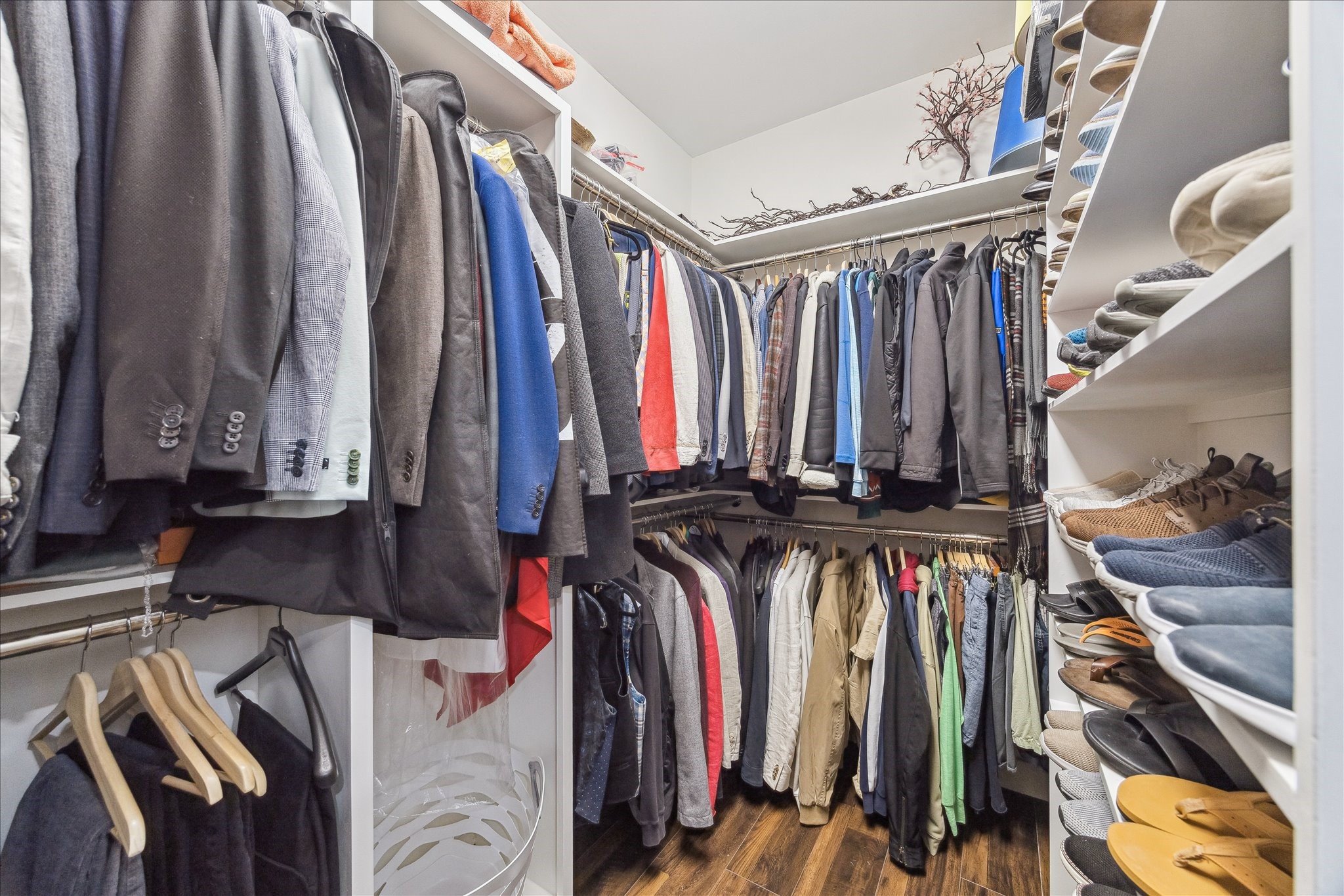 2100 Tanglewilde Street, Unit 373 Houston, TX 77063 - Photo 14 of 21 This photo shows a spacious walk-in closet with ample shelving and hanging space. It features neatly organized storage, with a luxury vinyl laminate floor and bright lighting, offering a practical and stylish storage solution.