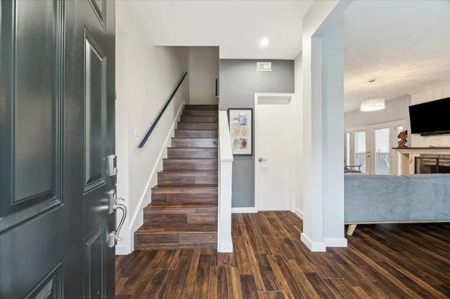 a view of a livingroom with wooden floor and staircase