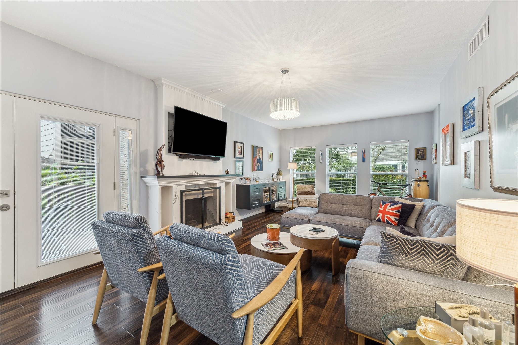 2100 Tanglewilde Street, Unit 373 Houston, TX 77063 - Photo 3 of 21 This inviting living room features a cozy corner sectional, and a mounted TV above a stylish fireplace. Large windows offer plenty of natural light, complementing the hardwood floors and contemporary decor.