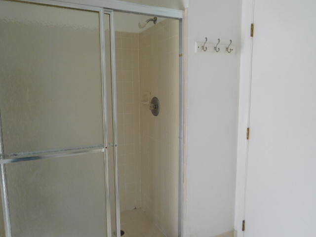 11504 Whisper Sound Drive Boca Raton, FL 33428 - Photo 17 of 32 a bathroom with a glass shower door
