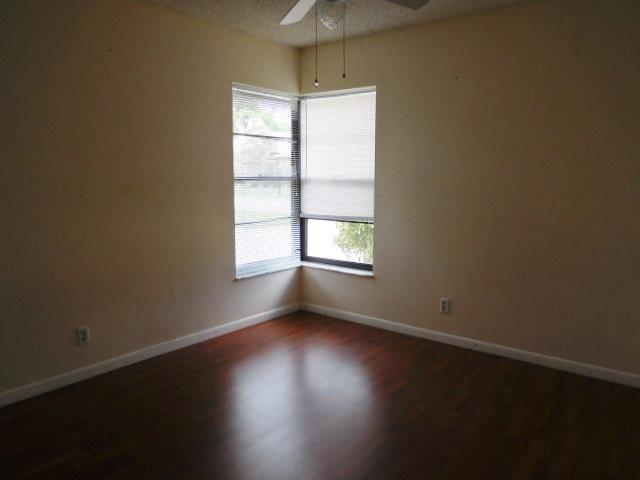 11504 Whisper Sound Drive Boca Raton, FL 33428 - Photo 18 of 32 an empty room with wooden floor and windows