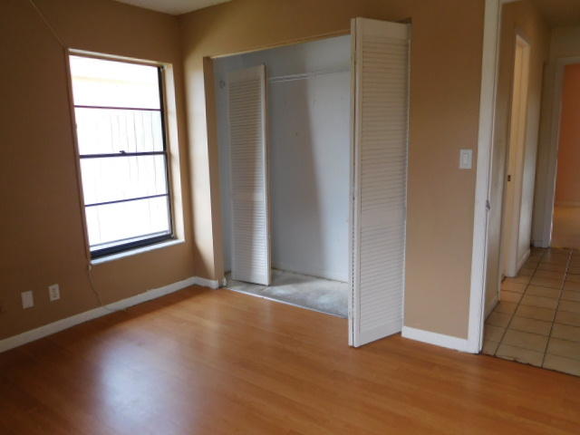 11504 Whisper Sound Drive Boca Raton, FL 33428 - Photo 22 of 32 an empty room with wooden floor and windows