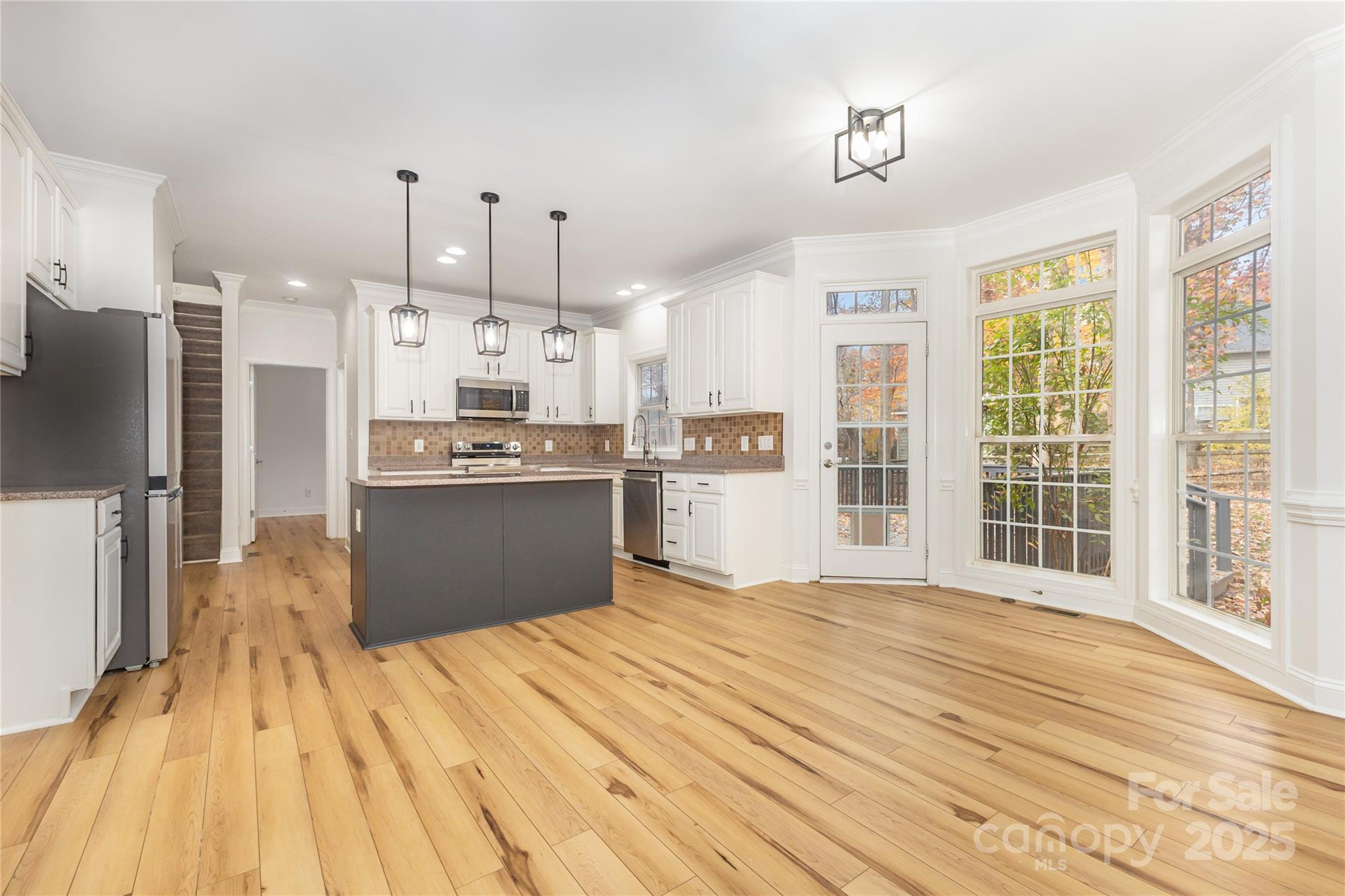 884 Clonmel Drive Matthews, NC 28104 - Photo 11 of 48 a kitchen with stainless steel appliances kitchen island wooden cabinets and refrigerator