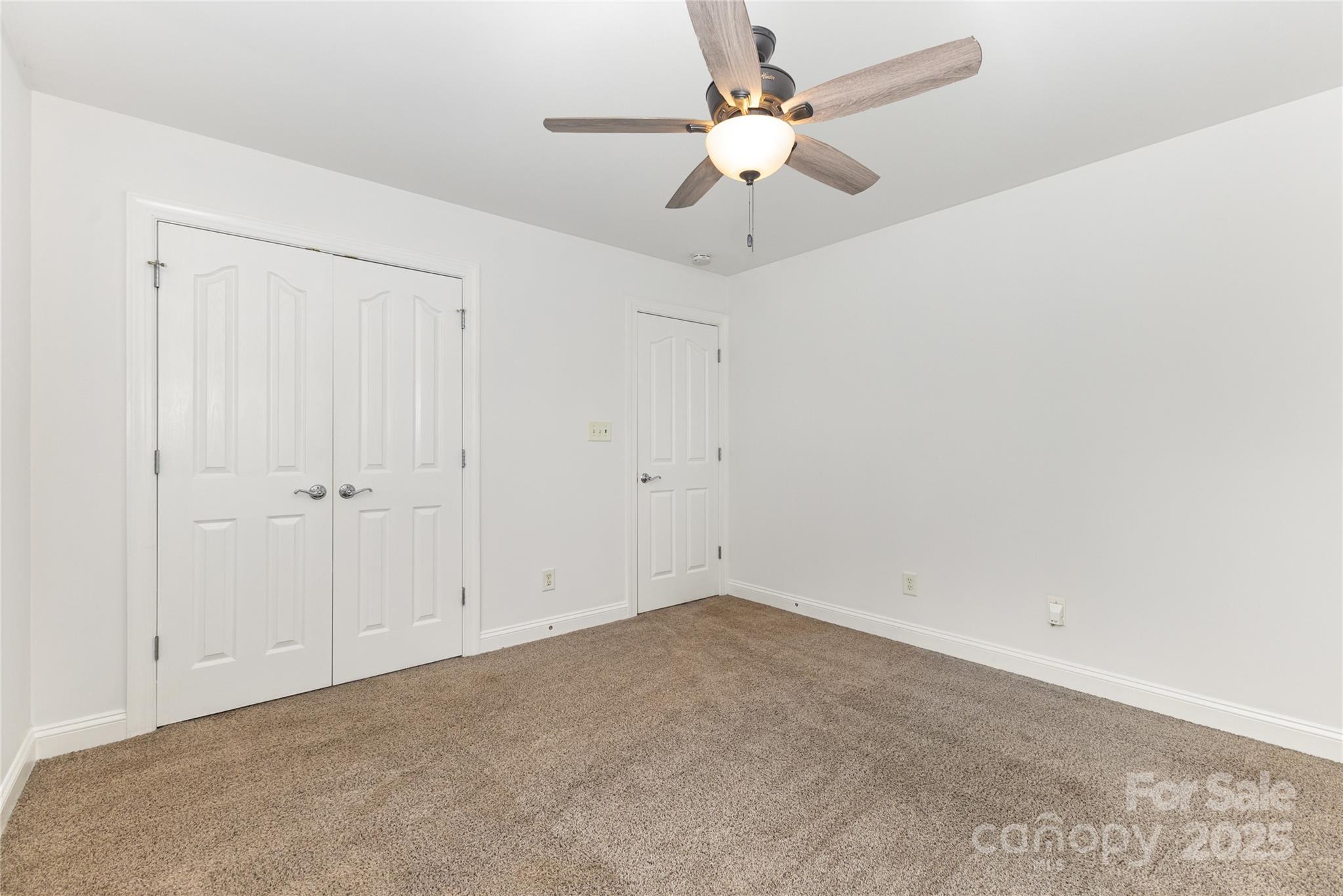 884 Clonmel Drive Matthews, NC 28104 - Photo 26 of 48 an empty room with a chandelier fan and windows