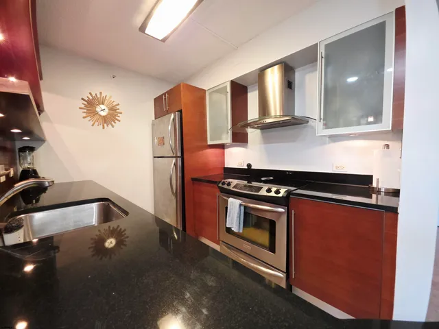 a kitchen with stainless steel appliances granite countertop a refrigerator and a stove