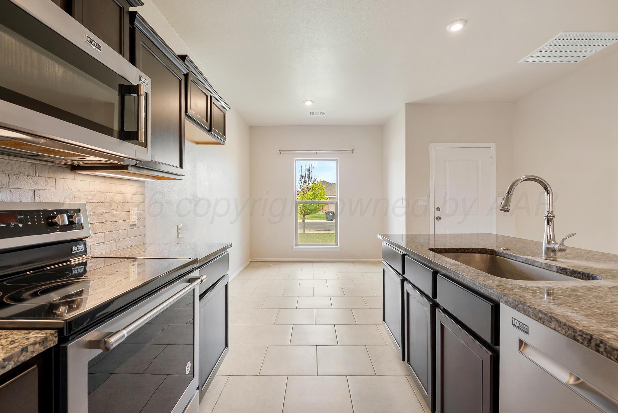 4807 Eberly Street Amarillo, TX 79118 - Photo 11 of 25 a kitchen that has a sink and a stove