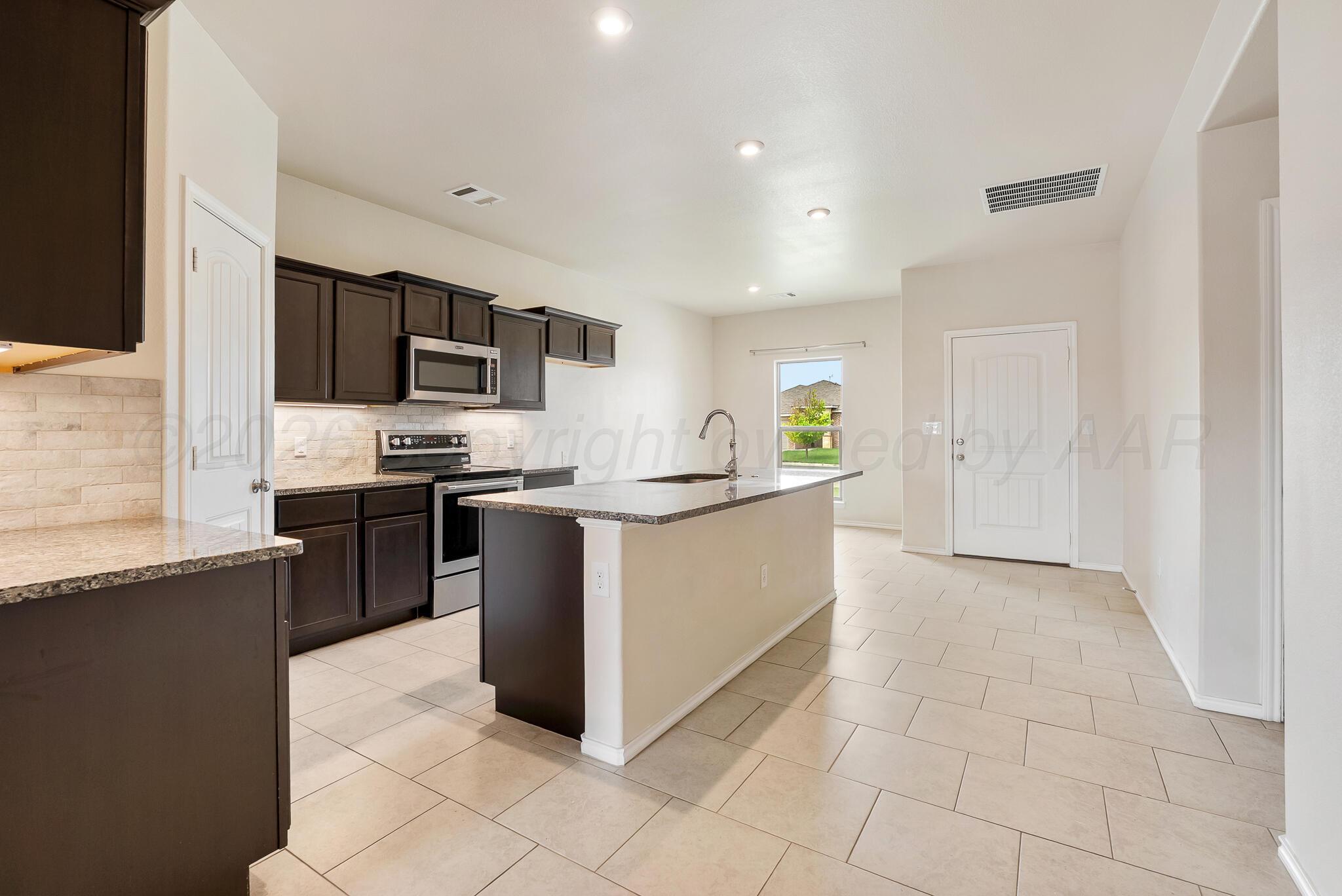 4807 Eberly Street Amarillo, TX 79118 - Photo 12 of 25 a kitchen with stainless steel appliances a refrigerator stove top oven and sink