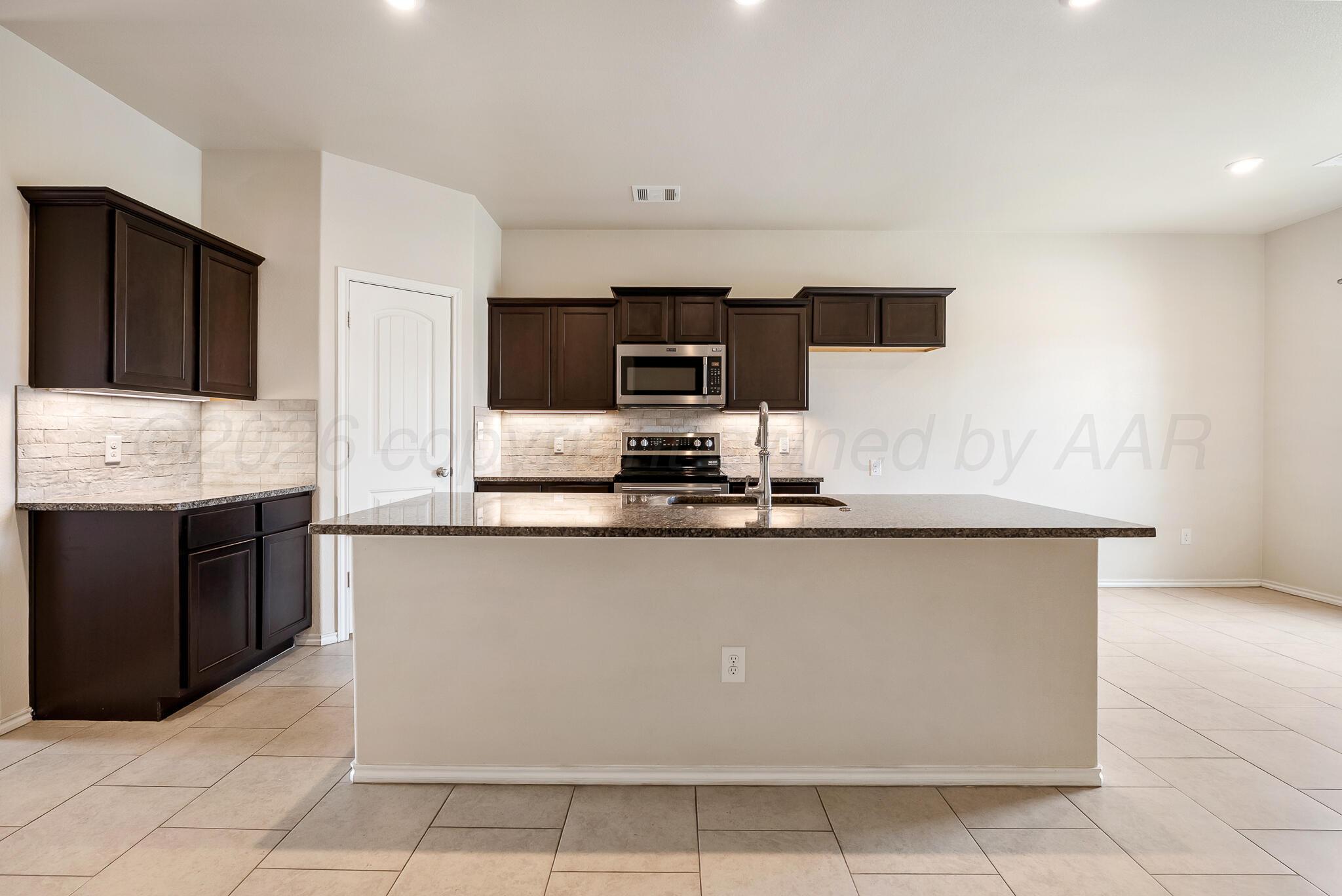 4807 Eberly Street Amarillo, TX 79118 - Photo 13 of 25 a kitchen with stainless steel appliances granite countertop a stove and a sink