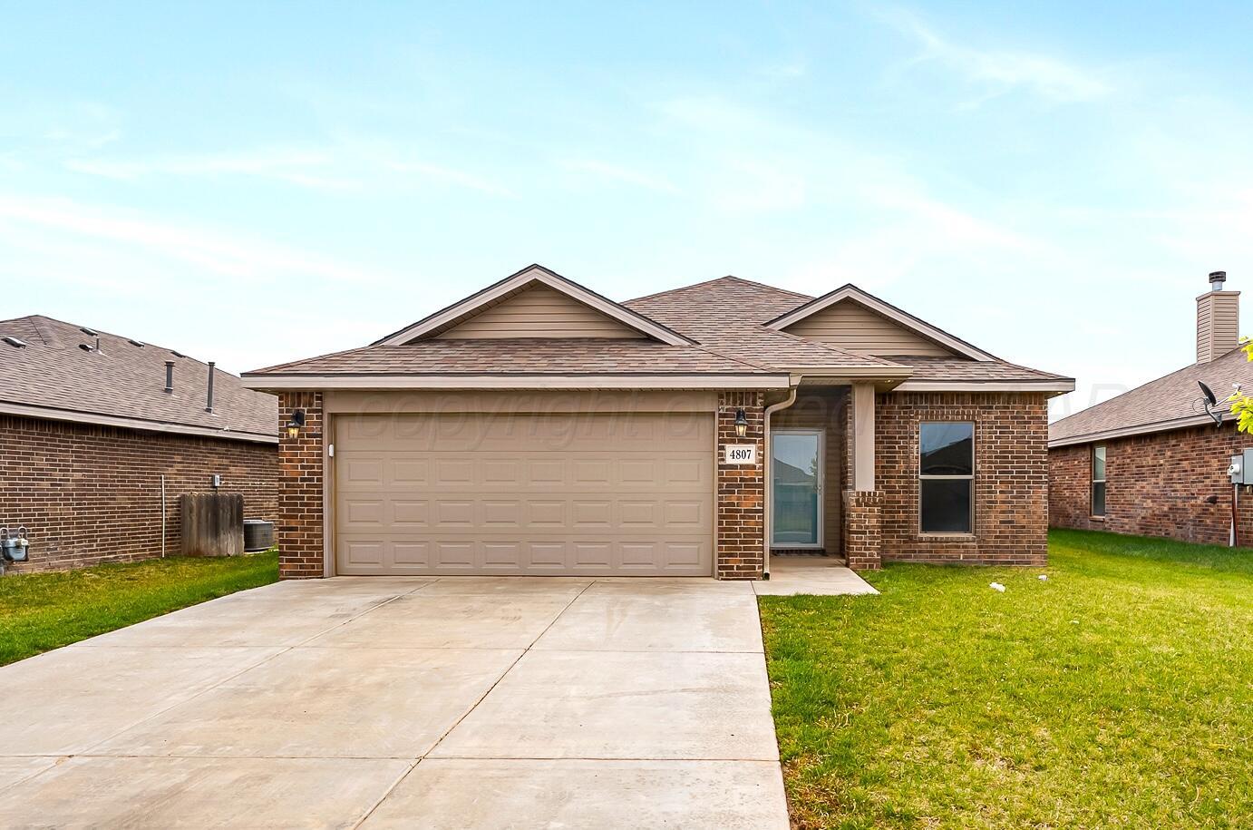 4807 Eberly Street Amarillo, TX 79118 - Photo 2 of 25 a front view of a house with a garden and garage