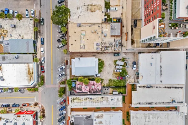 an aerial view of residential houses with outdoor space and parking