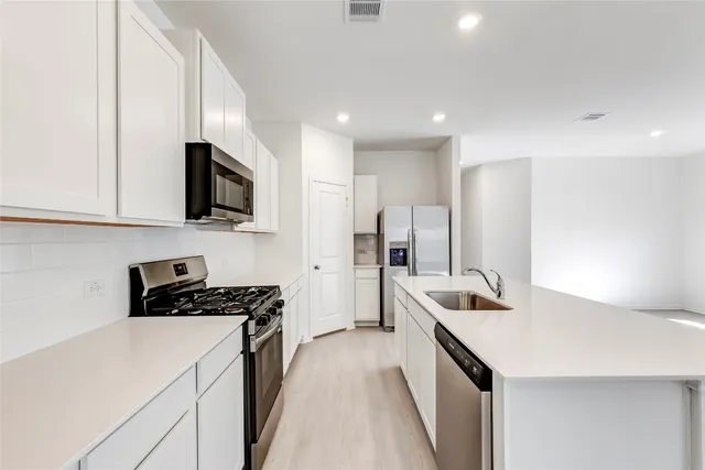 a kitchen that has a sink and a stove in it