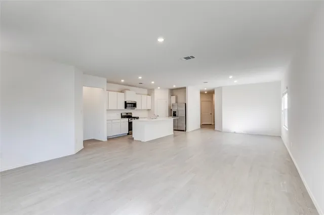 a view of kitchen with kitchen island white cabinets and stainless steel appliances