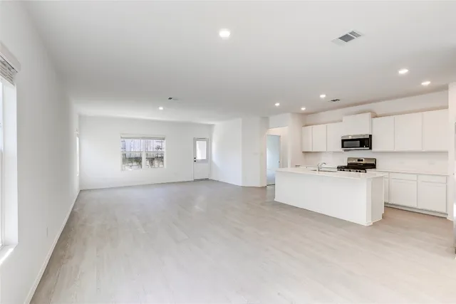 a kitchen with white cabinets and stainless steel appliances