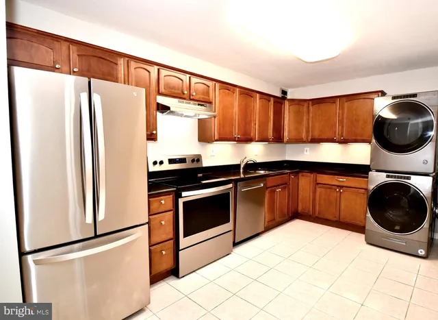 a kitchen with stainless steel appliances granite countertop a refrigerator sink and stove