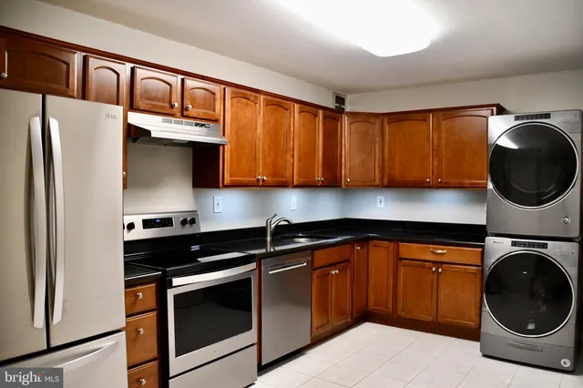 a kitchen with stainless steel appliances granite countertop a stove a sink and a refrigerator