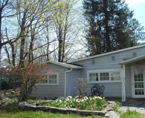 a front view of a house with a yard and a garden