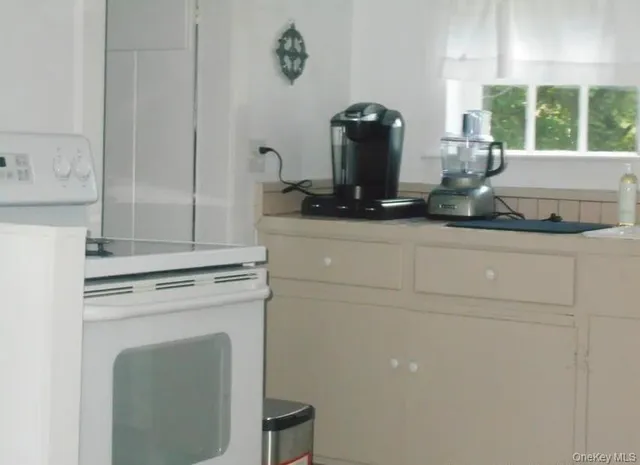 a kitchen with a stove and white cabinets
