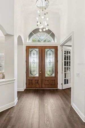 a bedroom with a bed a chandelier and dresser