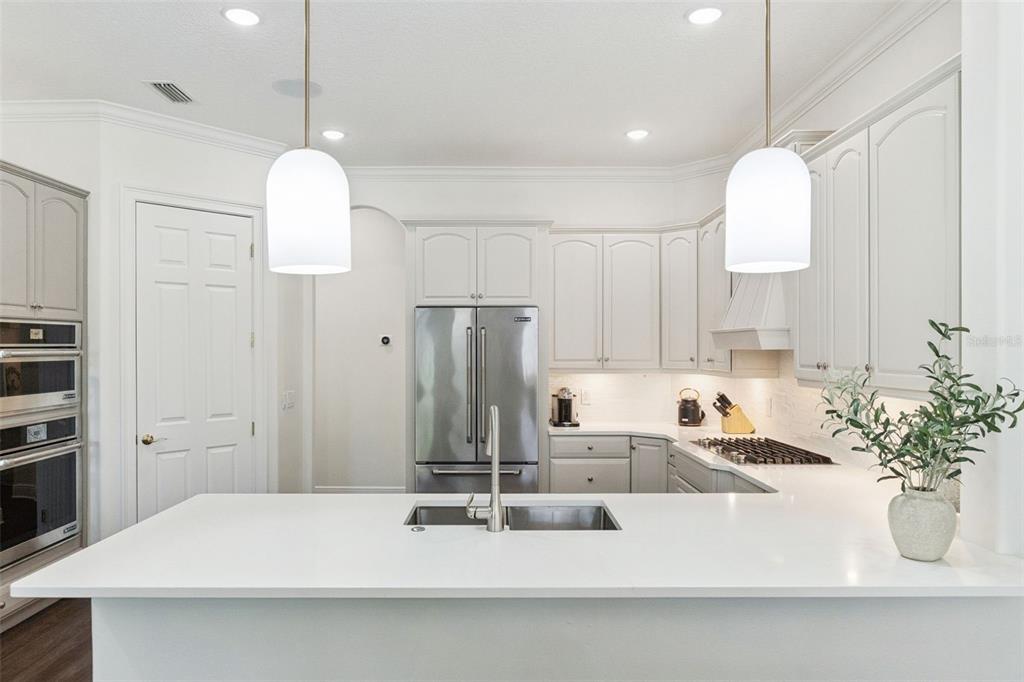6110 Keenes Pointe Drive Windermere, FL 34786 - Photo 30 of 78 a kitchen with kitchen island a sink and a chandelier