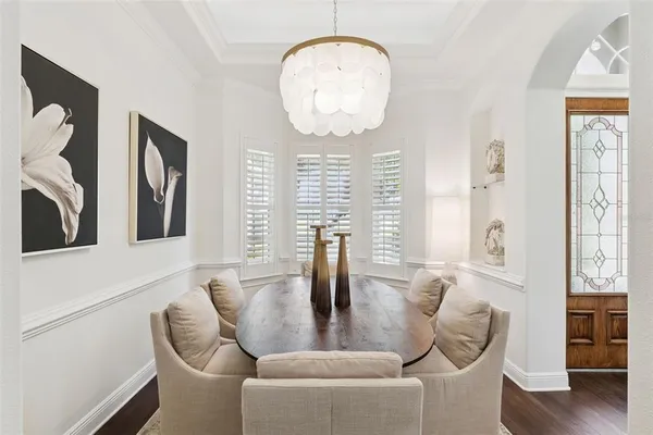 a living room with furniture a large window and wooden floor