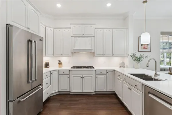 a kitchen with white cabinets white stainless steel appliances and sink