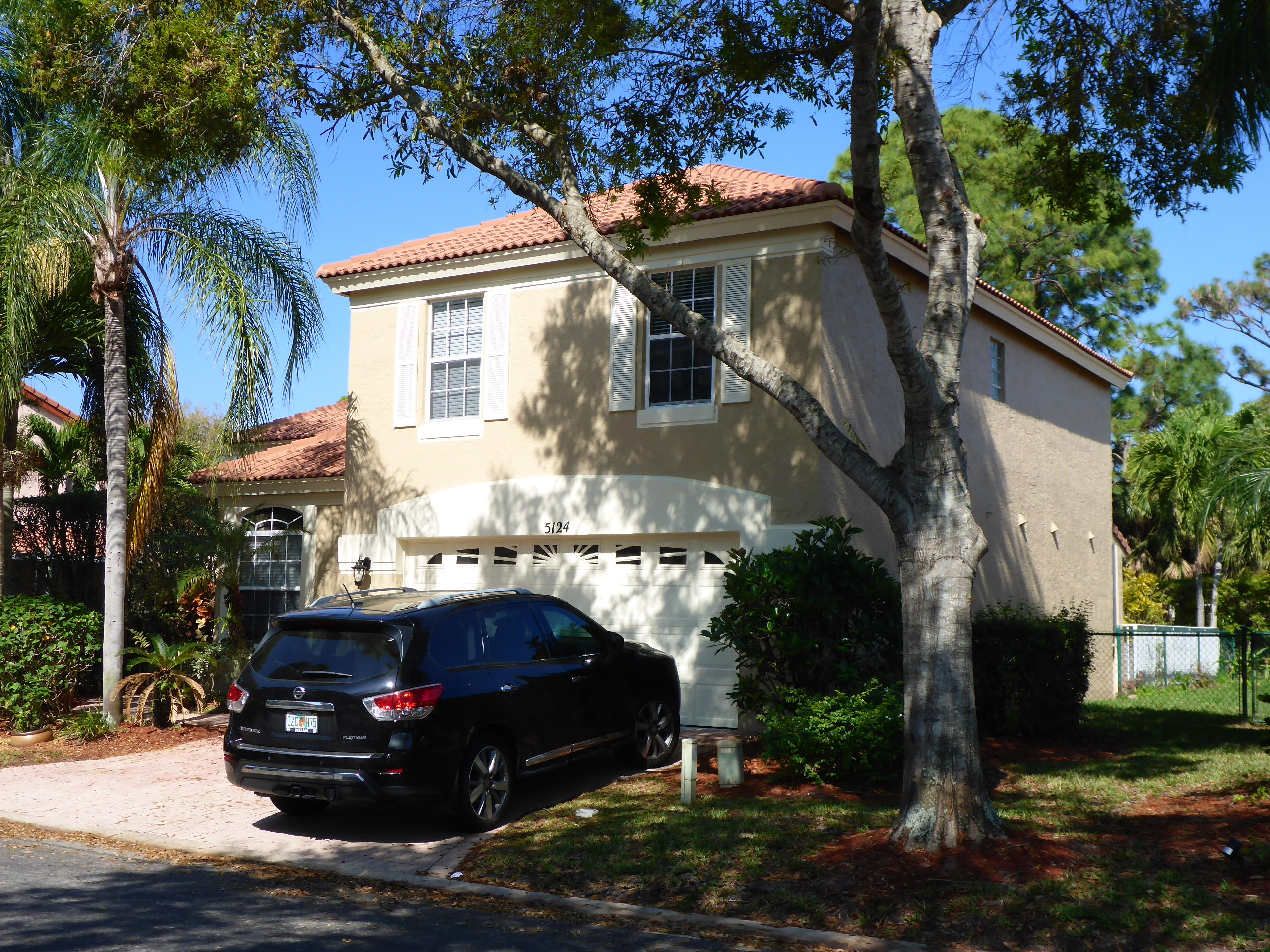 5124 Elpine Way Riviera Beach, FL 33418 - Photo 1 of 45 a car parked in front of a white house
