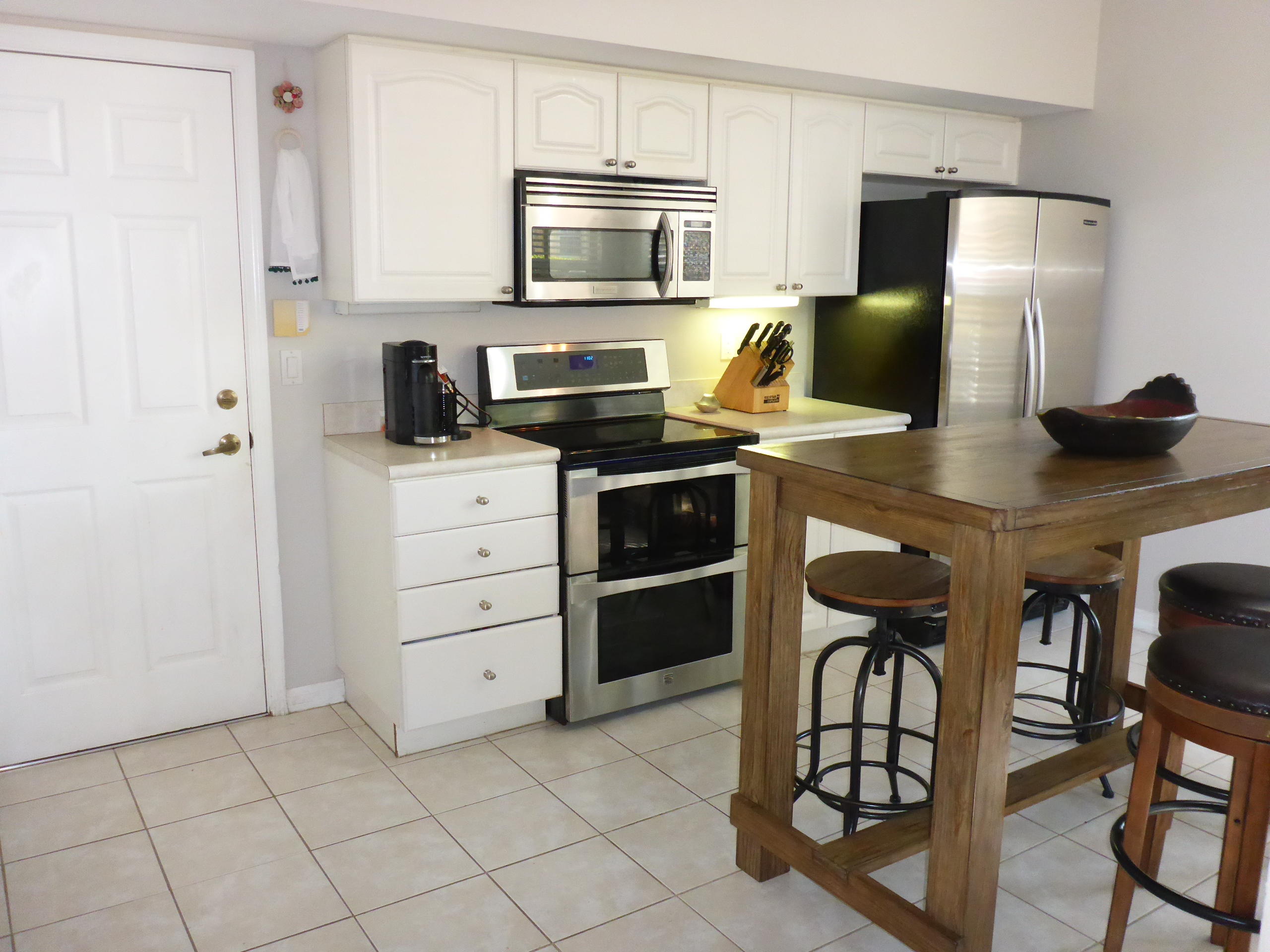 5124 Elpine Way Riviera Beach, FL 33418 - Photo 13 of 45 a kitchen with stainless steel appliances a stove refrigerator sink and cabinets