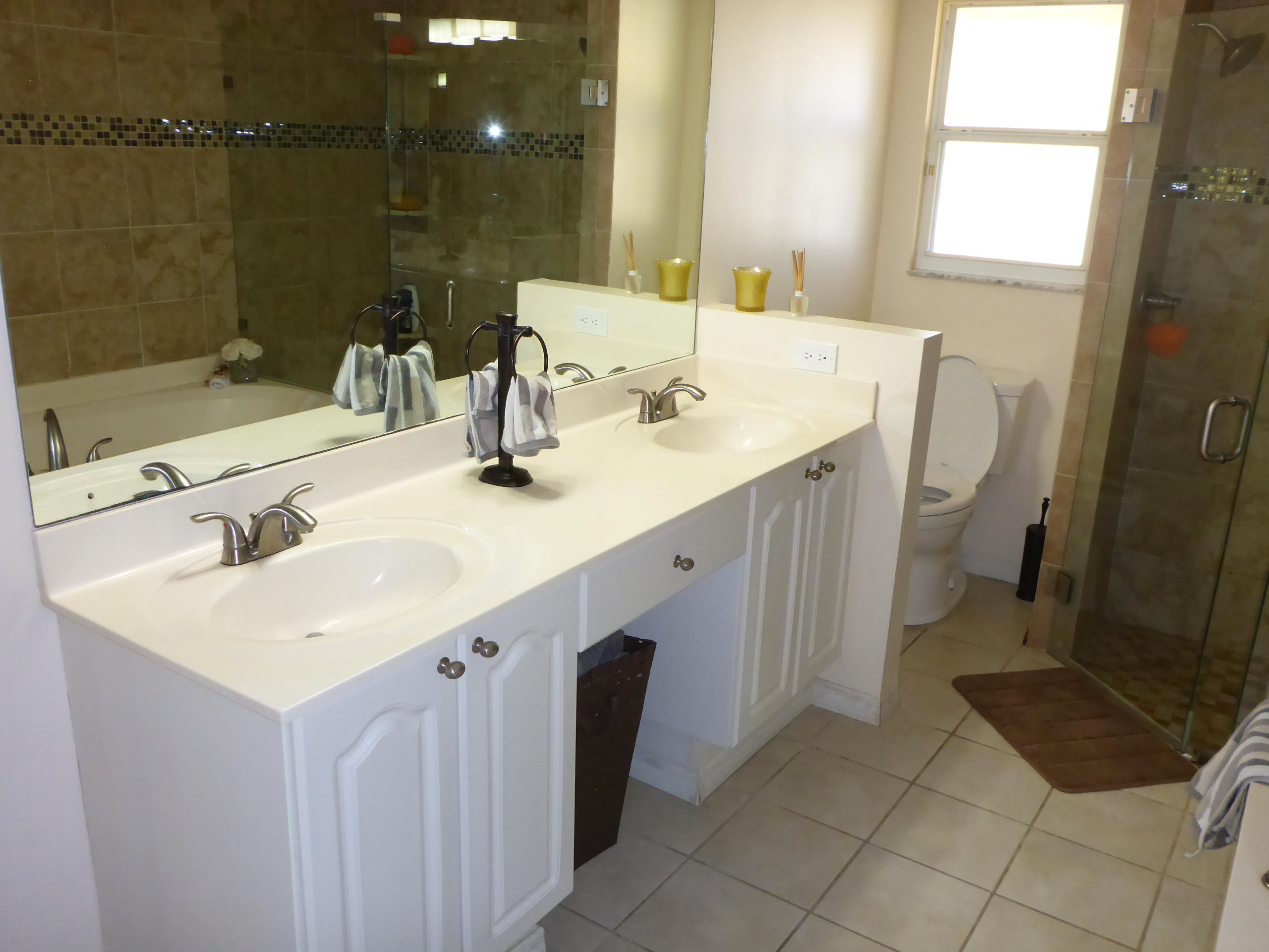 5124 Elpine Way Riviera Beach, FL 33418 - Photo 25 of 45 a bathroom with a sink a toilet and a mirror