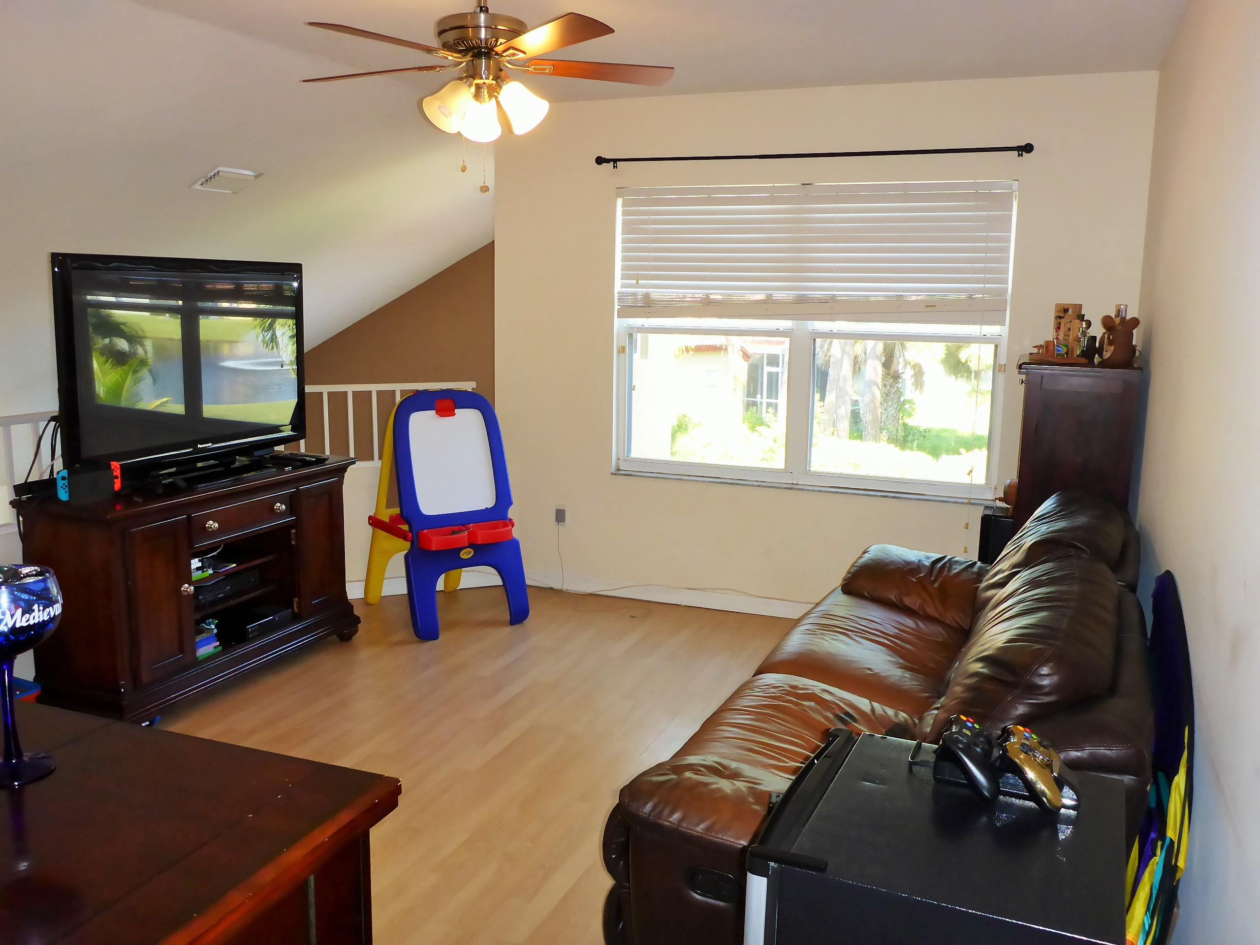 5124 Elpine Way Riviera Beach, FL 33418 - Photo 29 of 45 a living room with furniture and a flat screen tv