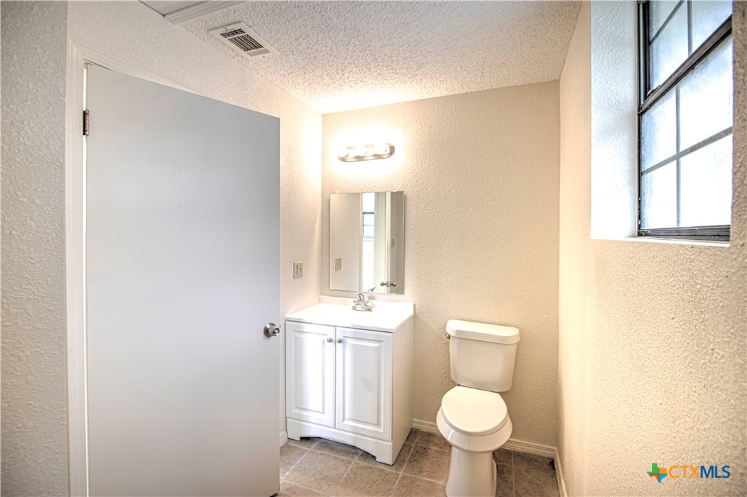 305 Tanglewood Road Temple, TX 76502 - Photo 44 of 46 a bathroom with a toilet sink and mirror