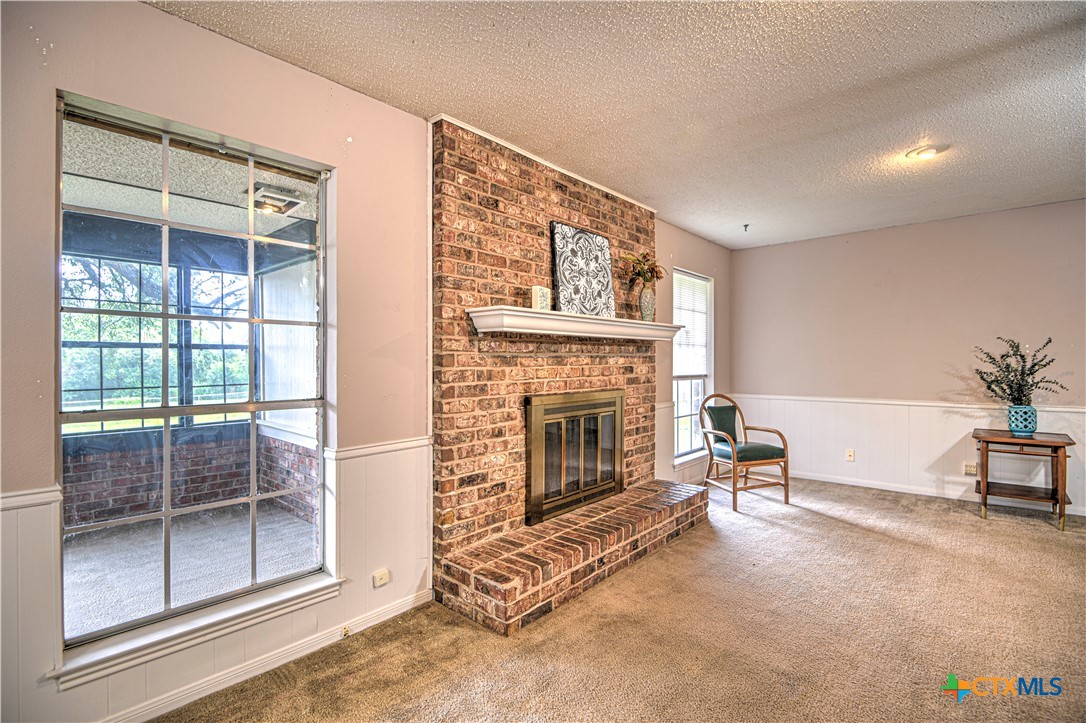 305 Tanglewood Road Temple, TX 76502 - Photo 7 of 46 a living room with furniture a fireplace and a floor to ceiling window