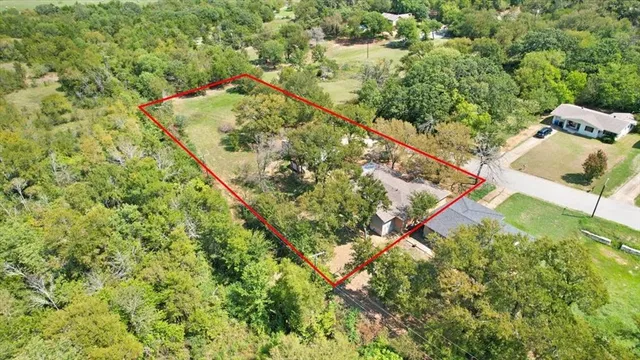 an aerial view of a house with a yard and green space