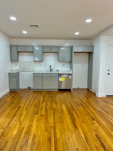 a large kitchen with stainless steel appliances granite countertop a sink and cabinets