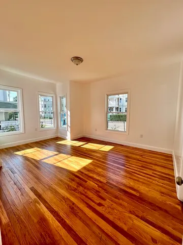 a view of a room with wooden floor and window