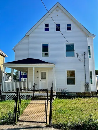 a view of a white house with yard in front of it