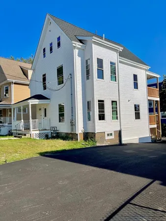 a front view of multiple houses with yard