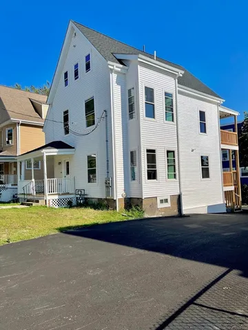a front view of multiple houses with yard