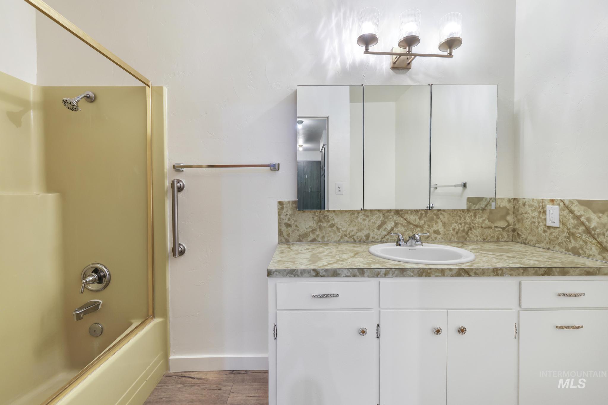 409 Clear Lakes Road Buhl, ID 83316 - Photo 19 of 43 Full bath with bathing tub / shower combination, vanity, and light wood-style floors