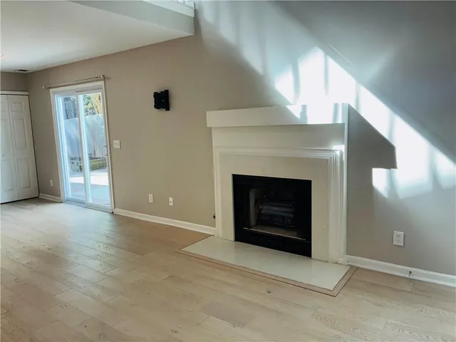 an empty room with a fireplace and window