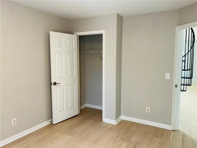 an empty room with windows and closet
