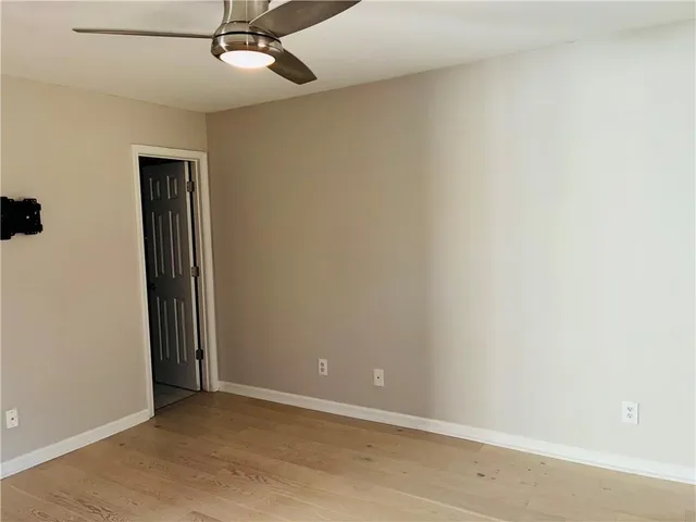 an empty room with a ceiling fan and carpet