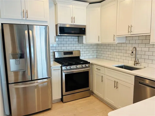 a kitchen with stainless steel appliances a refrigerator stove and microwave