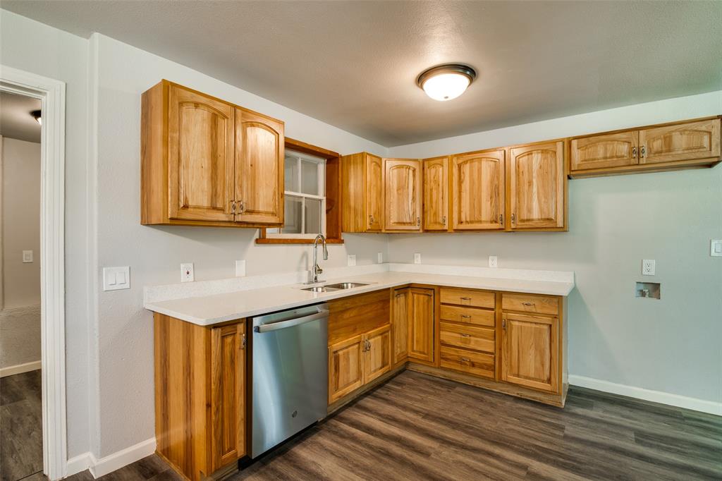 606 West High Street Terrell, TX 75160 - Photo 12 of 28 a kitchen with stainless steel appliances granite countertop a sink and cabinets with wooden floor