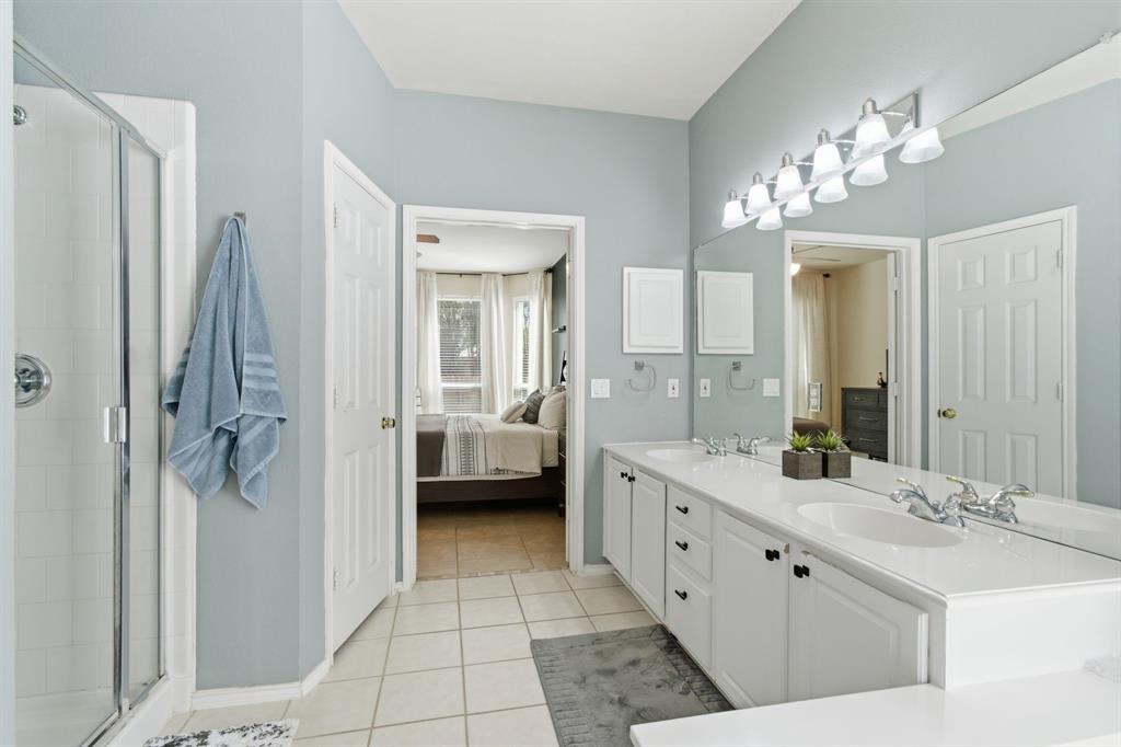 6625 Hayling Way Denton, TX 76210 - Photo 18 of 33 a spacious bathroom with a double vanity sink a mirror and a shower