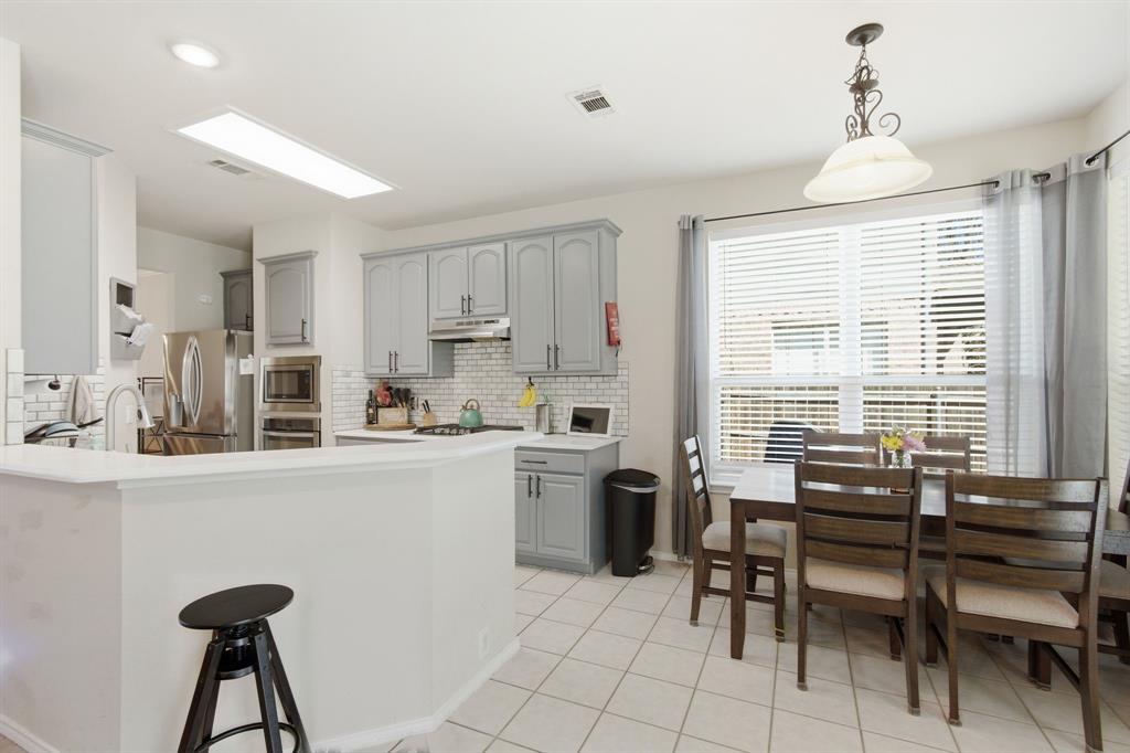 6625 Hayling Way Denton, TX 76210 - Photo 9 of 33 a kitchen with a table chairs sink and cabinets
