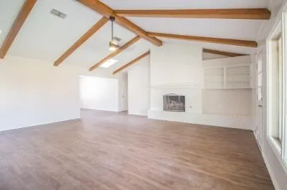 a view of empty room with wooden floor