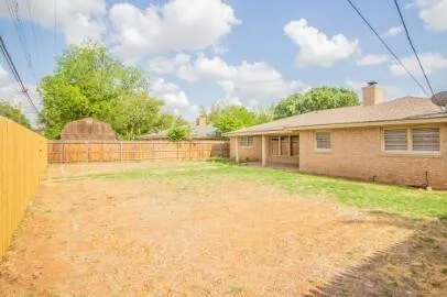 a view of a house with a backyard and a tree